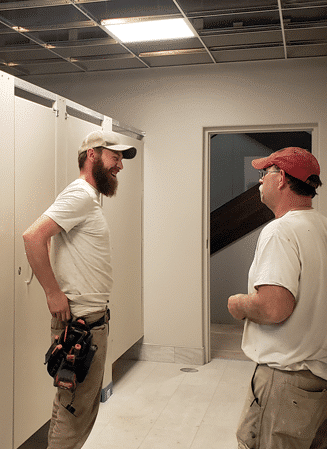 Partition Plus installer working on a restroom stall