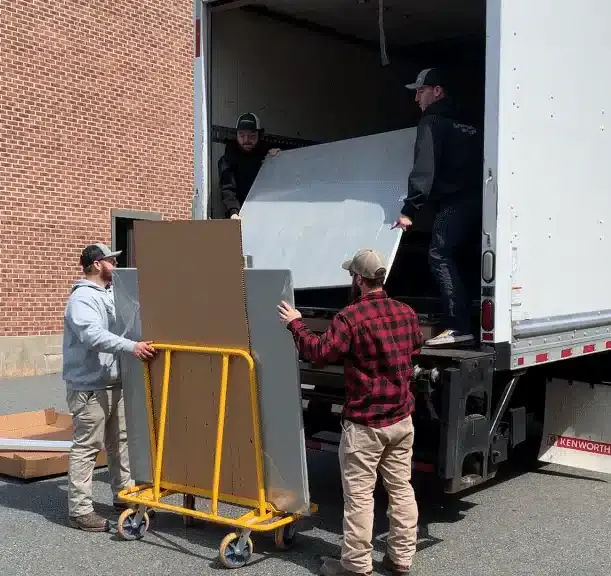 Photo of three installers unloading toilet partitions from a truck