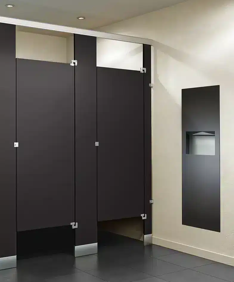 Black solid phenolic toilet partitions in a commercial restroom