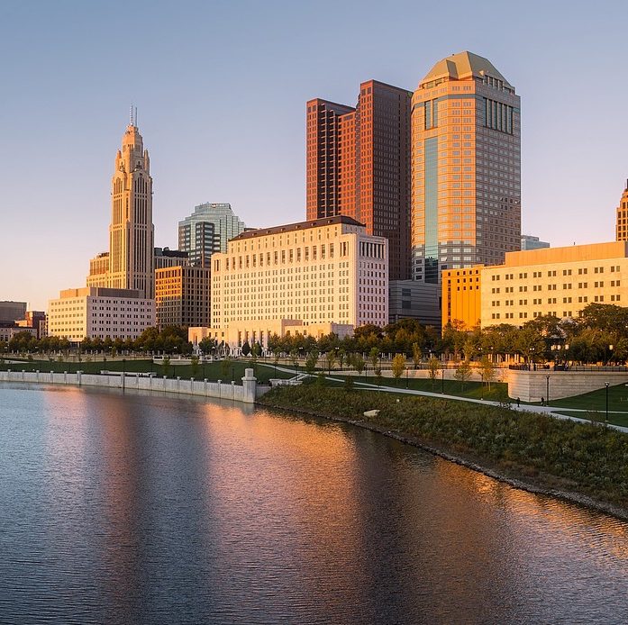 The skyscrapers of Columbus are located near the riverbank. The best bathroom partitions are water resistant. Partition Plus sells and installs water proof, phenolic bathroom partitions in the Columbus, Ohio area. Photograph of Columbus, Ohio skyscrapers near a body of water.