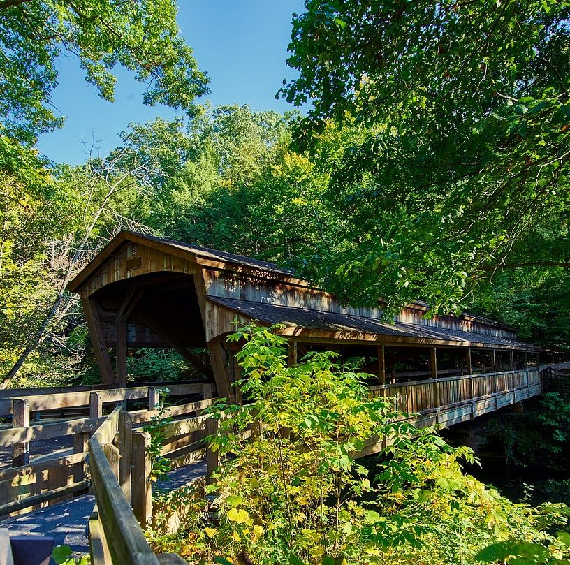 Visitors enjoy rustic footbridges in the Ohio countryside. Visitors to your public restrooms might not enjoy worn partitions and accessories. Partition Plus offers a range of new bathroom stalls in Columbus, Ohio and surrounding midwestern cities. Photograph of a covered footbridge in wooded area in Ohio.