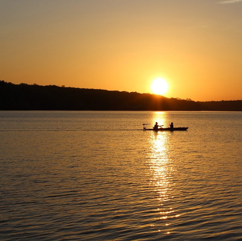 Photograph of canoers on lake in Rhode Island, at sunset.