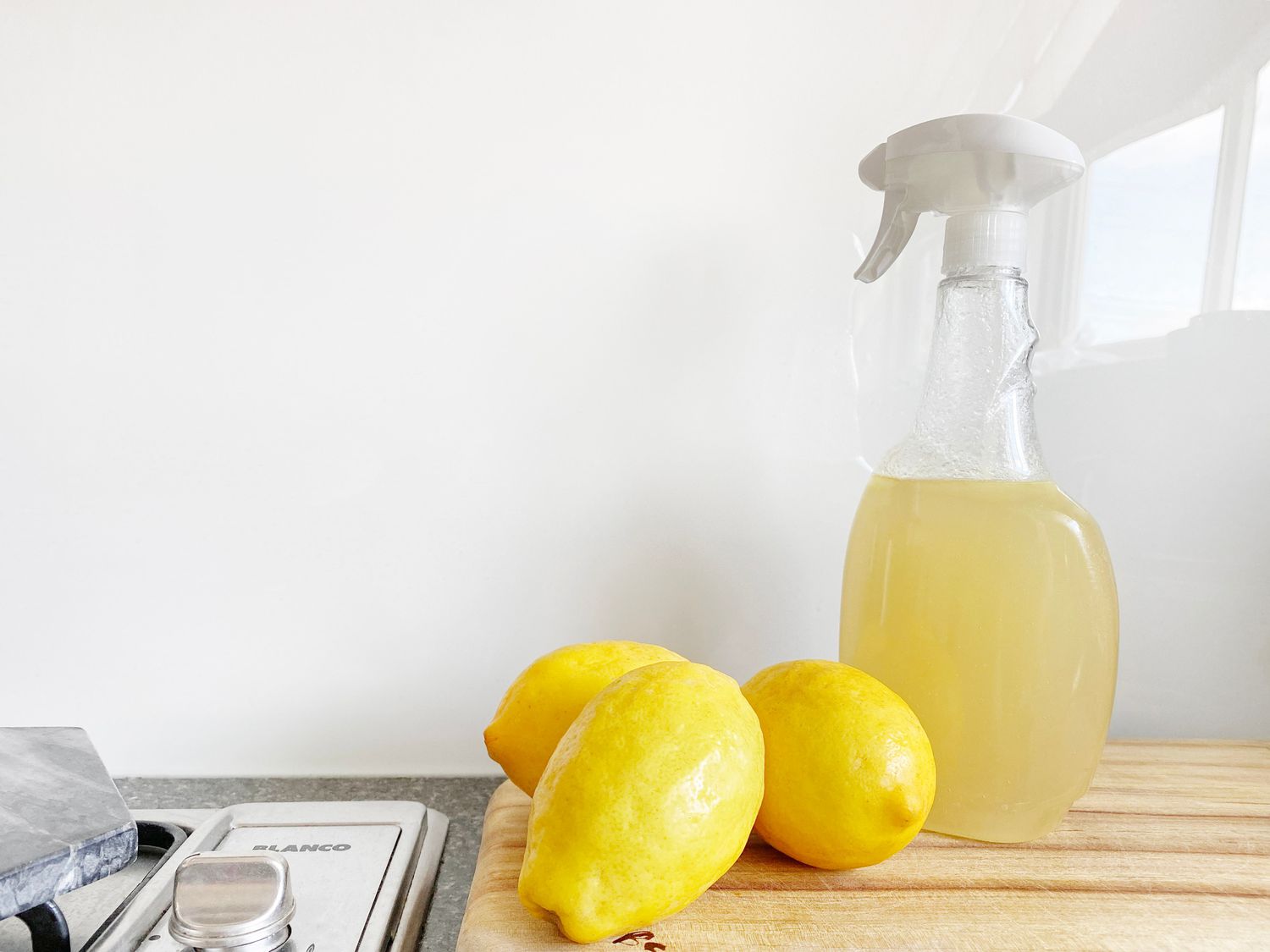 Lemons beside a spray bottle of cleaner