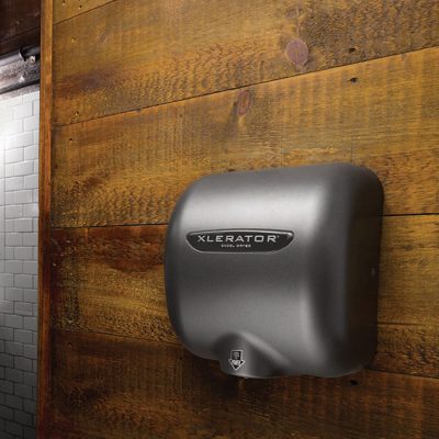 Graphite Textured Painted Excel XLERATOR hand dryer against rustic wood.